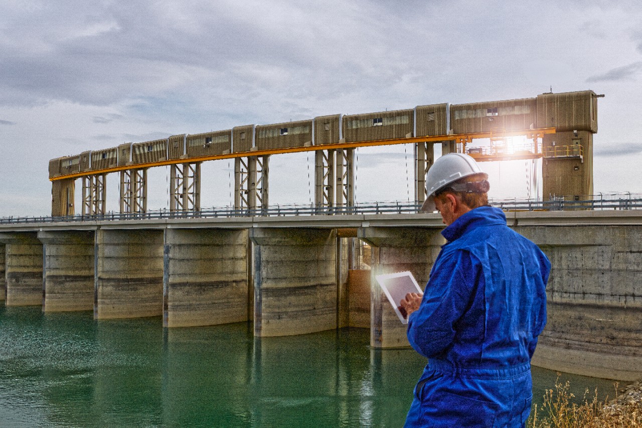 Engineer inspecting a hydroelectric dam. He uses a tablet device to record and communicate data. (Please see my portfolio for related video clips).