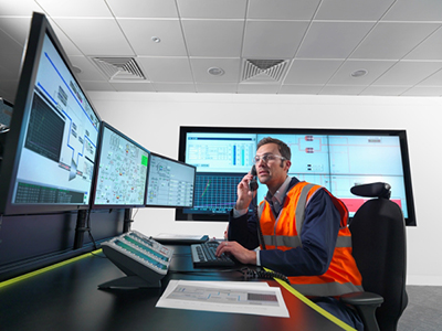 worker in control room with screens